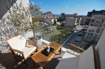 a balcony with a table and chairs and a view of a city at Leona Residences Apartment in Budva