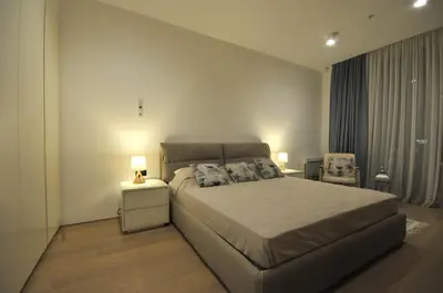 a bedroom with a large bed and a chair at Leona Residences Apartment in Budva