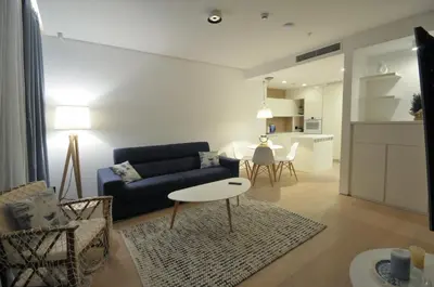 a living room with a blue couch and a table at Leona Residences Apartment in Budva