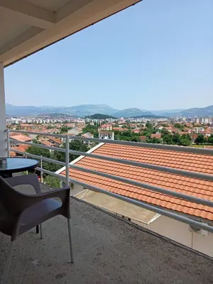 a balcony with a table and a chair and a view at Apartments Šofranac in Podgorica