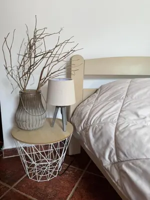 a lamp and a vase on a table next to a bed at Apartment Damjan in Kotor