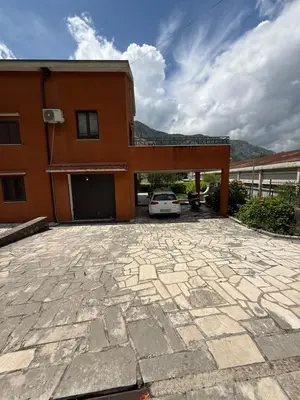 a house with a car parked in the driveway at Apartment Damjan in Kotor