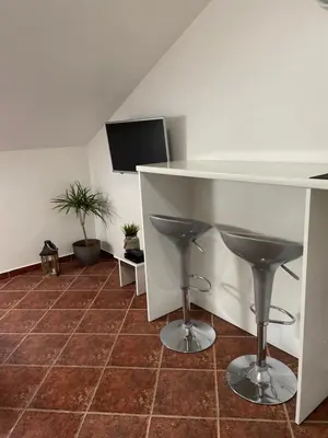 a bar with two stools and a tv in a room at Apartment Damjan in Kotor
