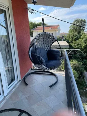 a black wicker chair sitting on a balcony at Apartments Neda in Sutomore
