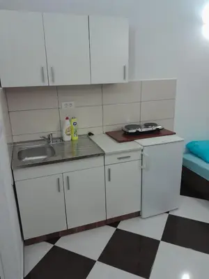 a small kitchen with white cabinets and a sink at Apartments Neda in Sutomore