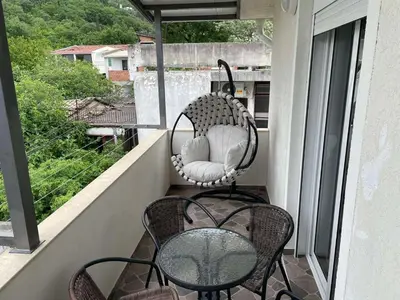 a balcony with a table and chairs on a balcony at Apartments Neda in Sutomore