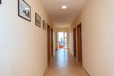 a hallway with white walls and a tile floor at Uphill Glavanovic Villas in Bar