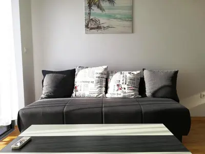 a couch in a living room with newspapers at Apartment Olive Montenegro KO Becici in Budva