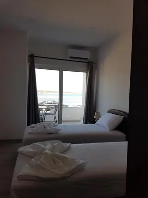 two beds in a room with a view of the ocean at Avdiu Apartment in Ulcinj