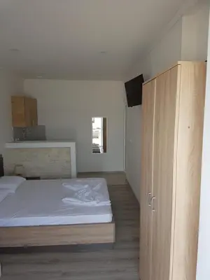 a bedroom with a bed and a wooden cabinet at Avdiu Apartment in Ulcinj