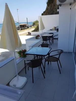 a patio with tables and chairs and an umbrella at Avdiu Apartment in Ulcinj
