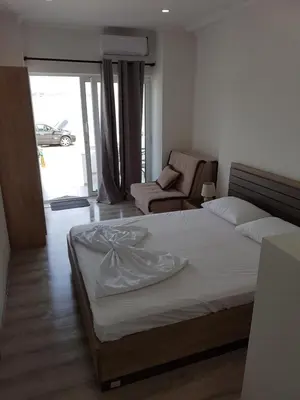a bedroom with a bed and a couch and a chair at Avdiu Apartment in Ulcinj