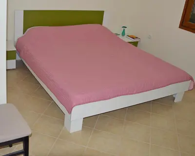 a bed in a room with a pink mattress at Guest House Radulovic in Petrovac na Moru