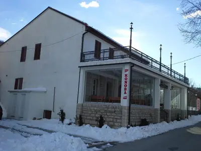 a white building with a balcony on top of it at BNB Njeguska sijela in Njeguši