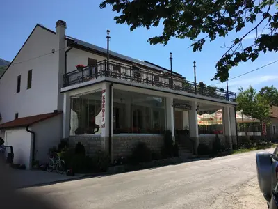 a white building with a balcony on top of it at BNB Njeguska sijela in Njeguši