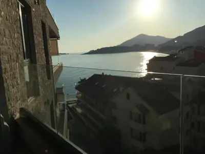 a view of the water from a balcony of a building at Apartment Sunset in Rafailovici