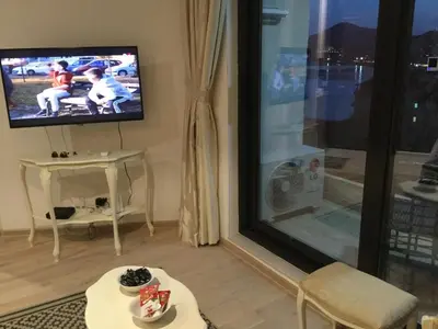 a living room with a flat screen tv on a wall at Apartment Sunset in Rafailovici