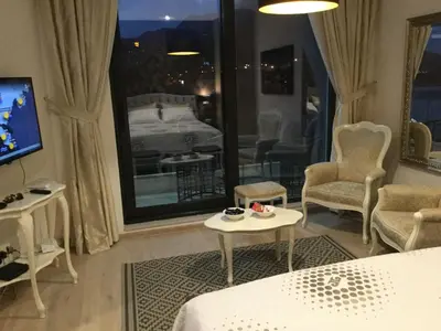a hotel room with a bed and a tv and a table at Apartment Sunset in Rafailovici