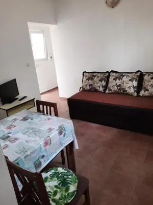a living room with a table and a couch at Apartmani na moru in Bar