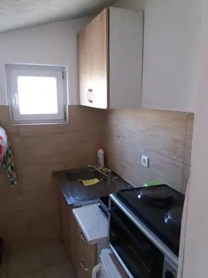 a small kitchen with a sink and a stove at Apartmani na moru in Bar
