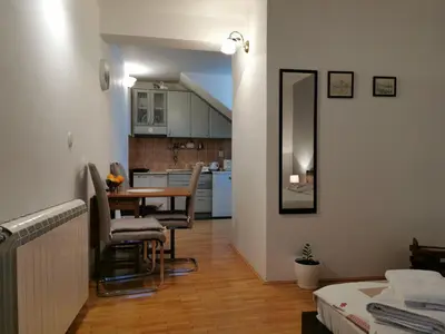 a living room with a table and a kitchen at Apartment Vukasevic in Virpazar