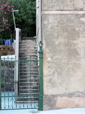 a staircase with a green gate next to a building at Ribica Apartments in Kotor
