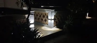 a stone wall with lights on it at night at Ribica Apartments in Kotor