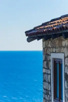a stone house with a window overlooking the ocean at Sunset Old Town in Ulcinj