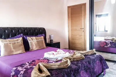 a bedroom with a bed with a purple comforter at Sunset Old Town in Ulcinj