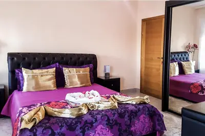 a bedroom with a purple bed with a mirror at Sunset Old Town in Ulcinj