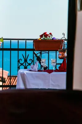 a table with wine glasses and a planter on a balcony at Sunset Old Town in Ulcinj