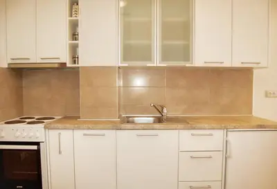 a kitchen with white cabinets and a sink at Vasiliki Seaside Apartments in Petrovac na Moru