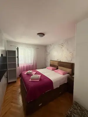 a bedroom with a large bed with pink pillows at Apartment Stana in Petrovac na Moru
