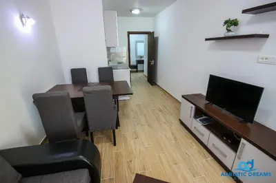 a living room with a dining room table and a television at Adriatic Dreams Apartments in Dobra Voda