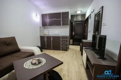 a living room with a couch and a table and a kitchen at Adriatic Dreams Apartments in Dobra Voda