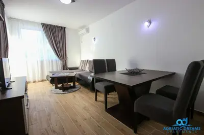 a living room with a table and a couch at Adriatic Dreams Apartments in Dobra Voda