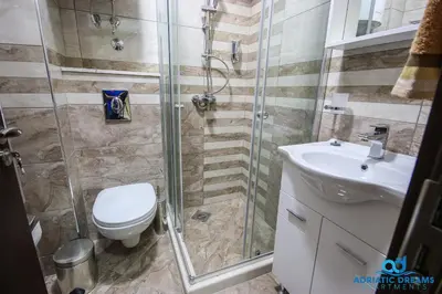 a bathroom with a shower and a toilet and a sink at Adriatic Dreams Apartments in Dobra Voda