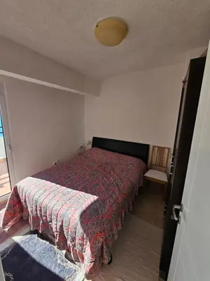 a small bedroom with a bed and a chair at Apartment Ralf in Ulcinj