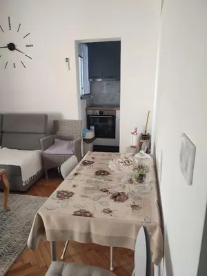 a living room with a table and a clock on the wall at Apartment Ralf in Ulcinj
