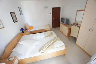 a bedroom with a bed and a desk with a television at Vila Mitrovich in Sveti Stefan