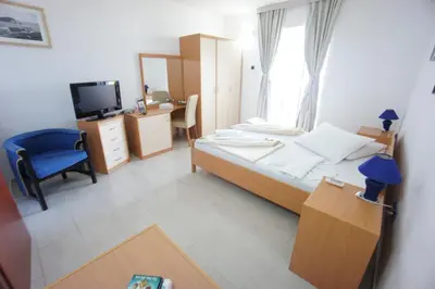 a bedroom with a bed and a desk and a television at Vila Mitrovich in Sveti Stefan