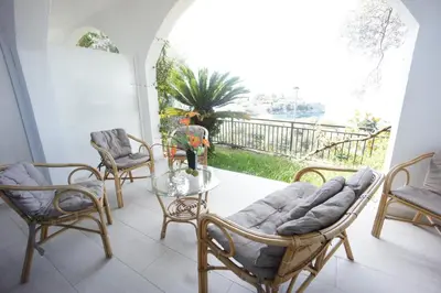 a living room with a glass table and chairs at Vila Mitrovich in Sveti Stefan