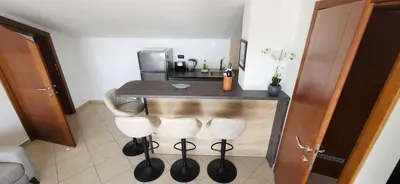 a kitchen with a counter with three bar stools at Vila Mitrovich in Sveti Stefan