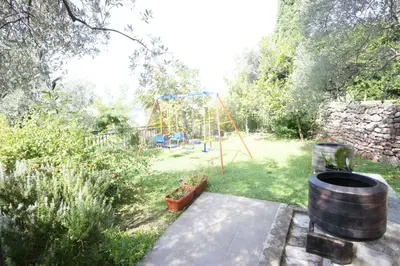 a garden with a playground in the background at Vila Mitrovich in Sveti Stefan