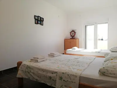 a white room with two beds and a window at Apart Forte Roses Montenegro KO Buljarica in Petrovac na Moru