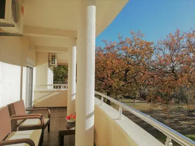 a balcony with chairs and a view of trees at Apart Forte Roses Montenegro KO Buljarica in Petrovac na Moru