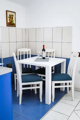 a white table with two chairs and a bottle of wine at Apartments Djukic in Tivat