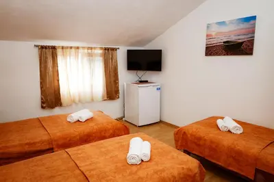 a hotel room with two beds and a television at Apartments Djukic in Tivat