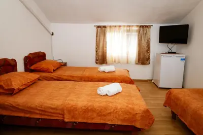 a hotel room with three beds with towels on them at Apartments Djukic in Tivat