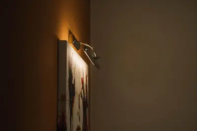 a light on a wall next to a painting on a wall at Apartments Antique in Ulcinj